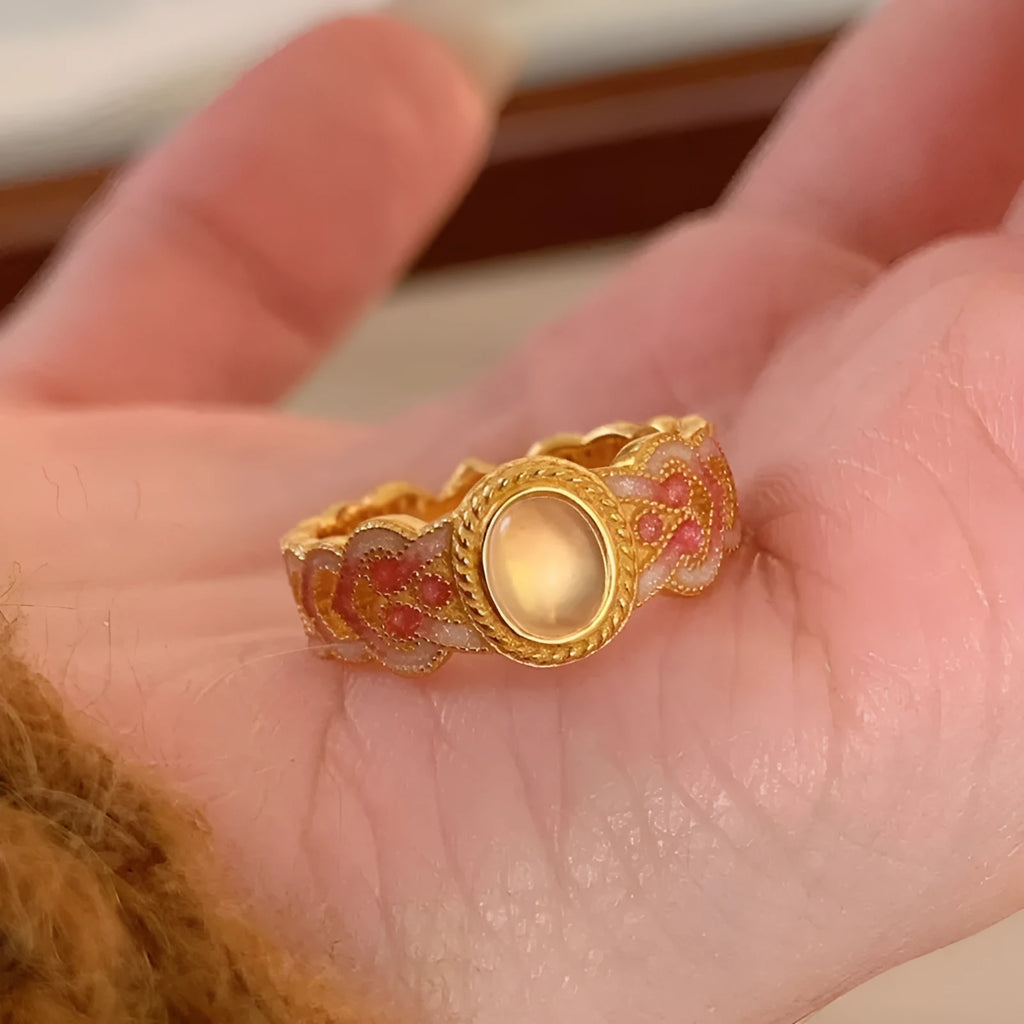 Geometric open mouth ring with pink crystal enamel on a gold-plated copper band.