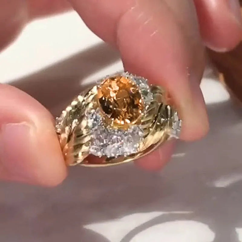 Gold-coloured copper ring with embossed feather pattern and yellow zircon stone