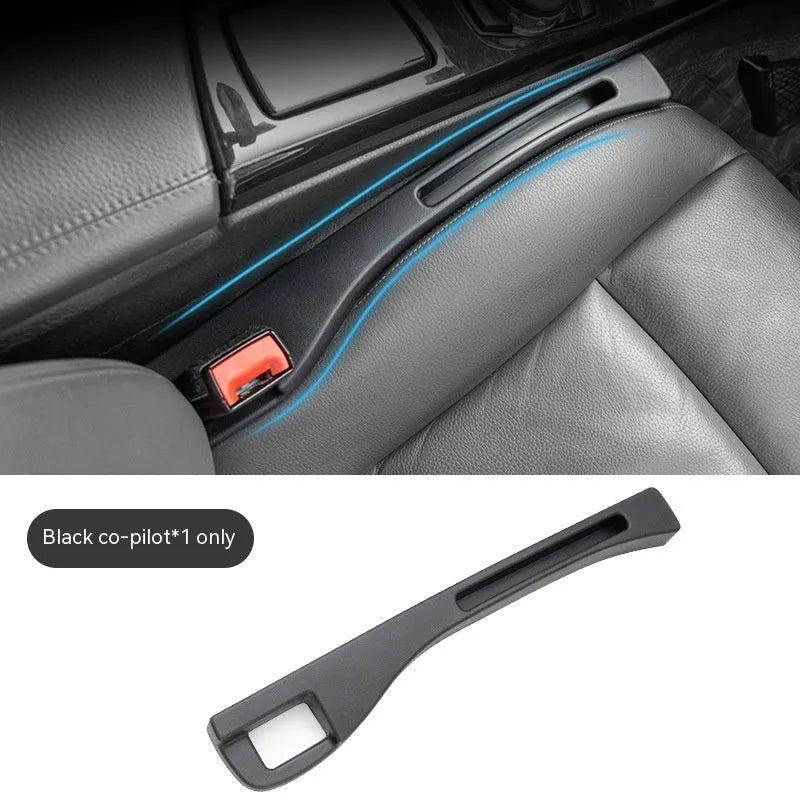 Black plastic car seat gap storage box with removal handle inserted between vehicle seats
