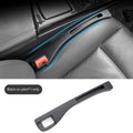 Black plastic car seat gap storage box with removal handle inserted between vehicle seats