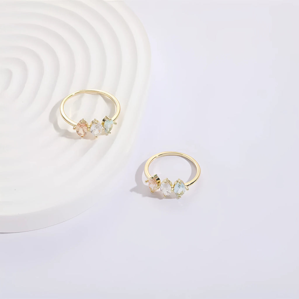 Geometric triangle ring with tricolour zircon birthstone in gold electroplated finish.