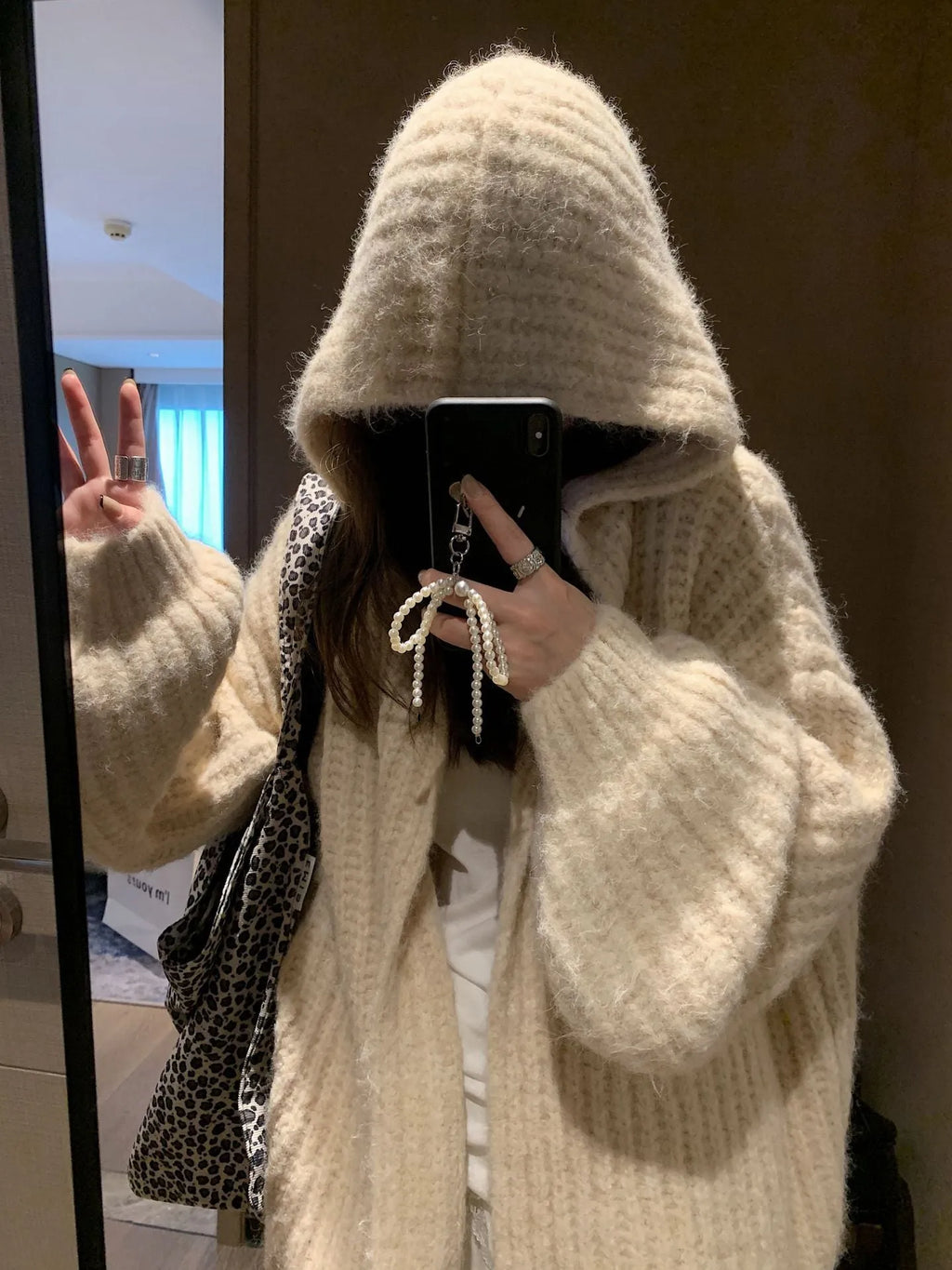 Brown women's loose-fit hooded acrylic sweater cardigan with retro style on a hanger.