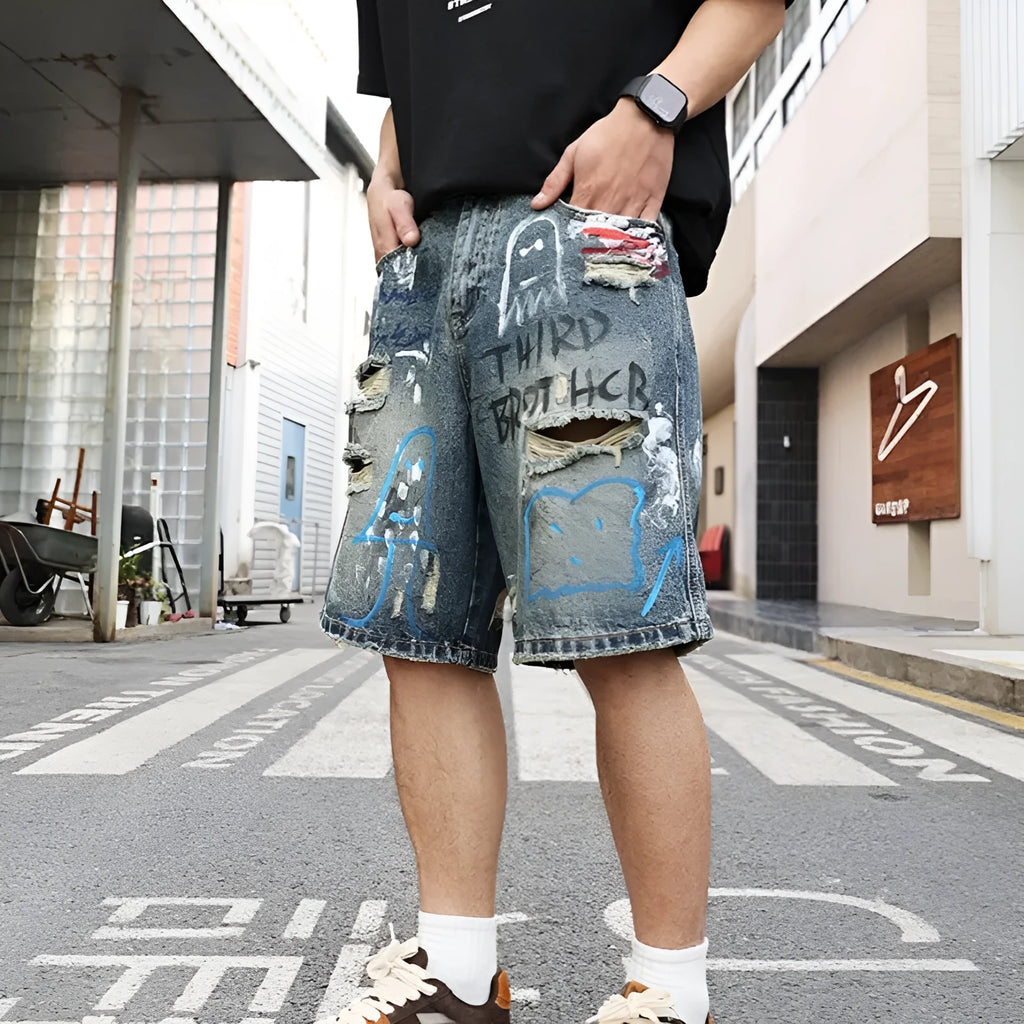 Blue ripped men's denim shorts with graffiti design and zipper fly