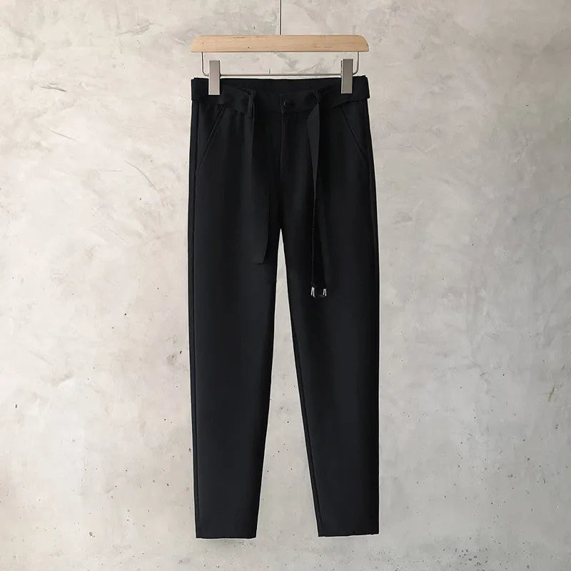 Boy wearing slim straight grey wool trousers with a tapered fit and straight leg opening.