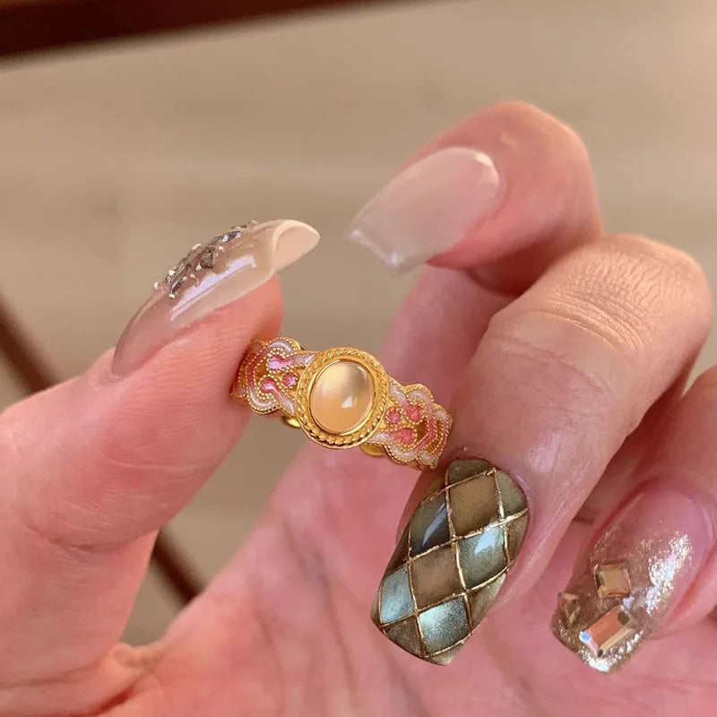 Geometric open mouth ring with pink crystal enamel on a gold-plated copper band.
