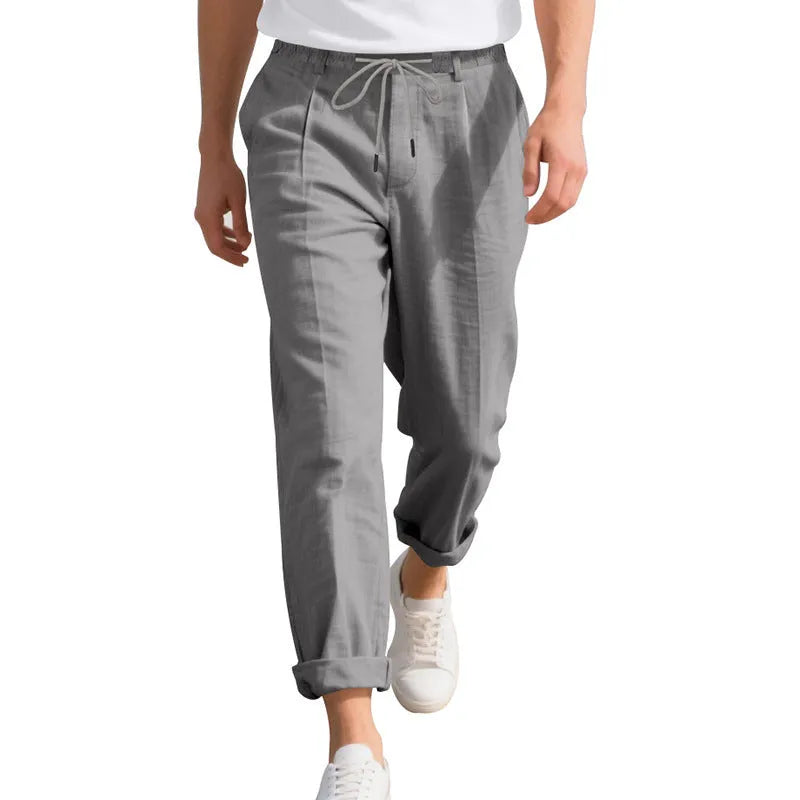 Men's light khaki linen casual trousers with drawstring waist and straight loose leg on hanger.