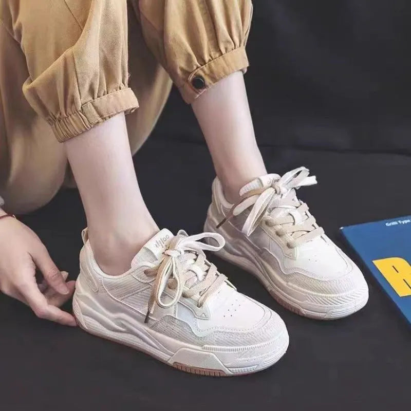 Pink and white low-top height-increasing sneakers with rubber soles on a plain background.