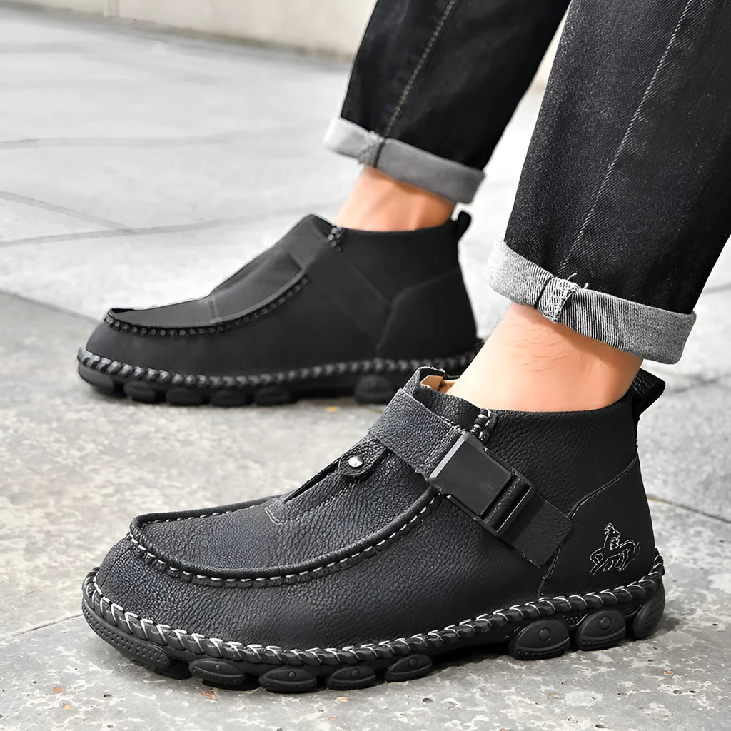 Men's black casual flat slip-on shoes with visible handmade stitching on the PU leather upper.