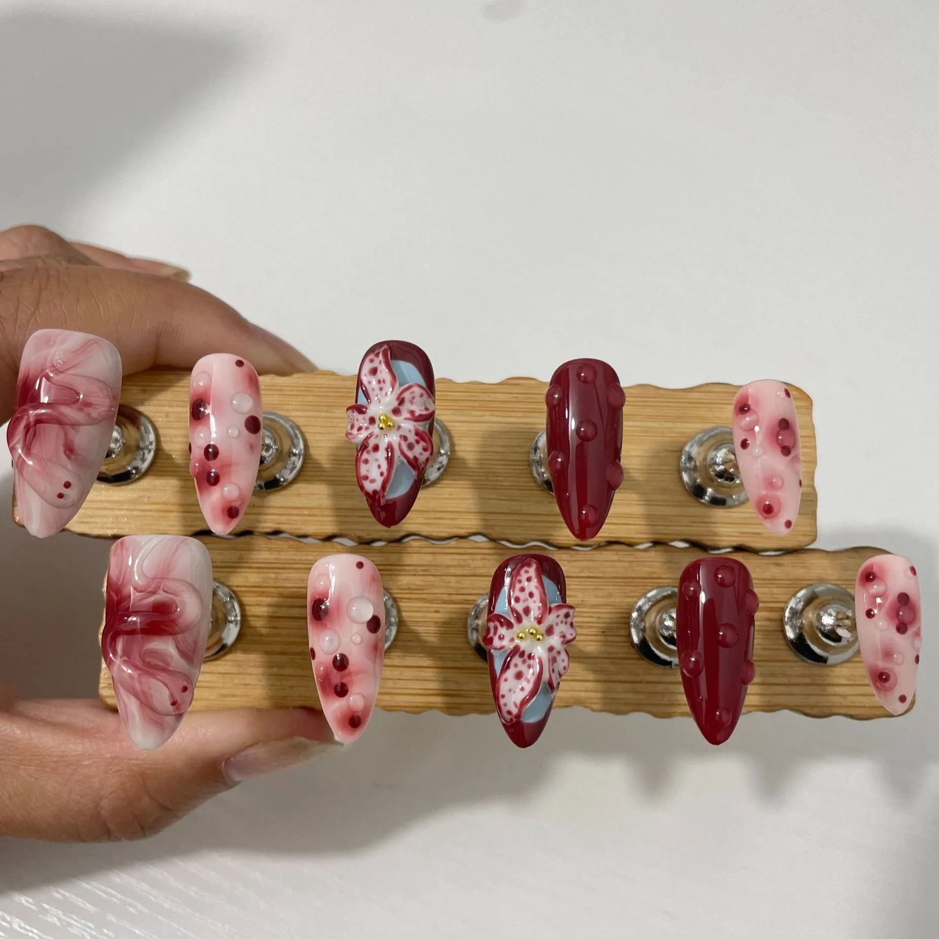 Hand-painted three-dimensional carved press-on nails with almond shape showing rose and tulip floral designs