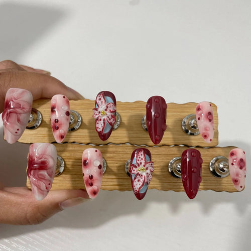 Hand-painted three-dimensional carved press-on nails with almond shape showing rose and tulip floral designs