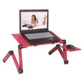 Black folding metal laptop desk with cooling holes extended over sofa