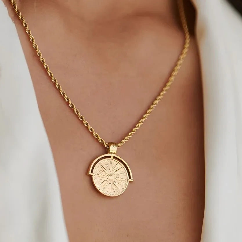 Gold titanium steel necklace with round embossed sunflower pendant and hemp chain.