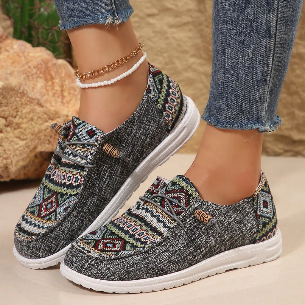 Women's flat slip-on shoes in black with round toe and rubber sole on a white background