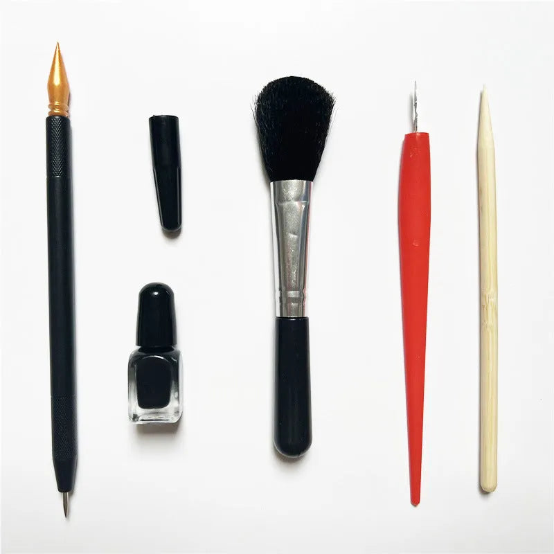 Scratch painting repair tool kit showing scratching pen, repair solution bottle, brushes, and bamboo sticks on a craft table.