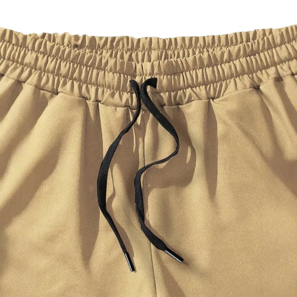 Khaki men's sports shorts with a white coconut leaf print, showing straight leg fit.