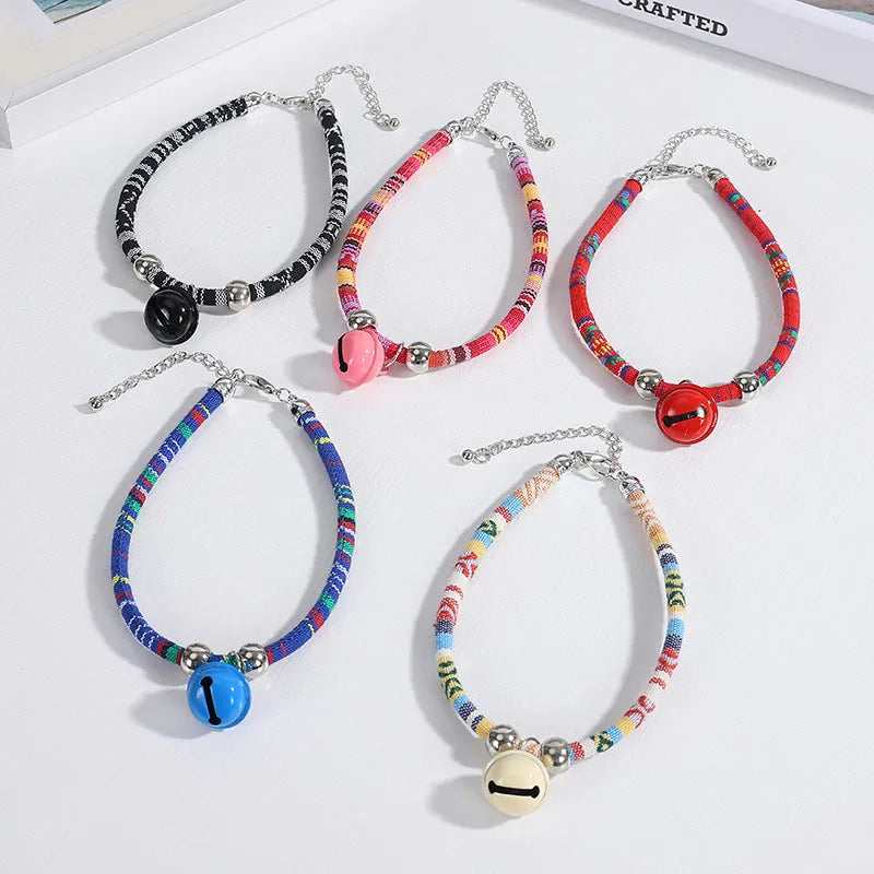 Colourful ethnic style adjustable dog collar with a bell, shown in multiple colour options.