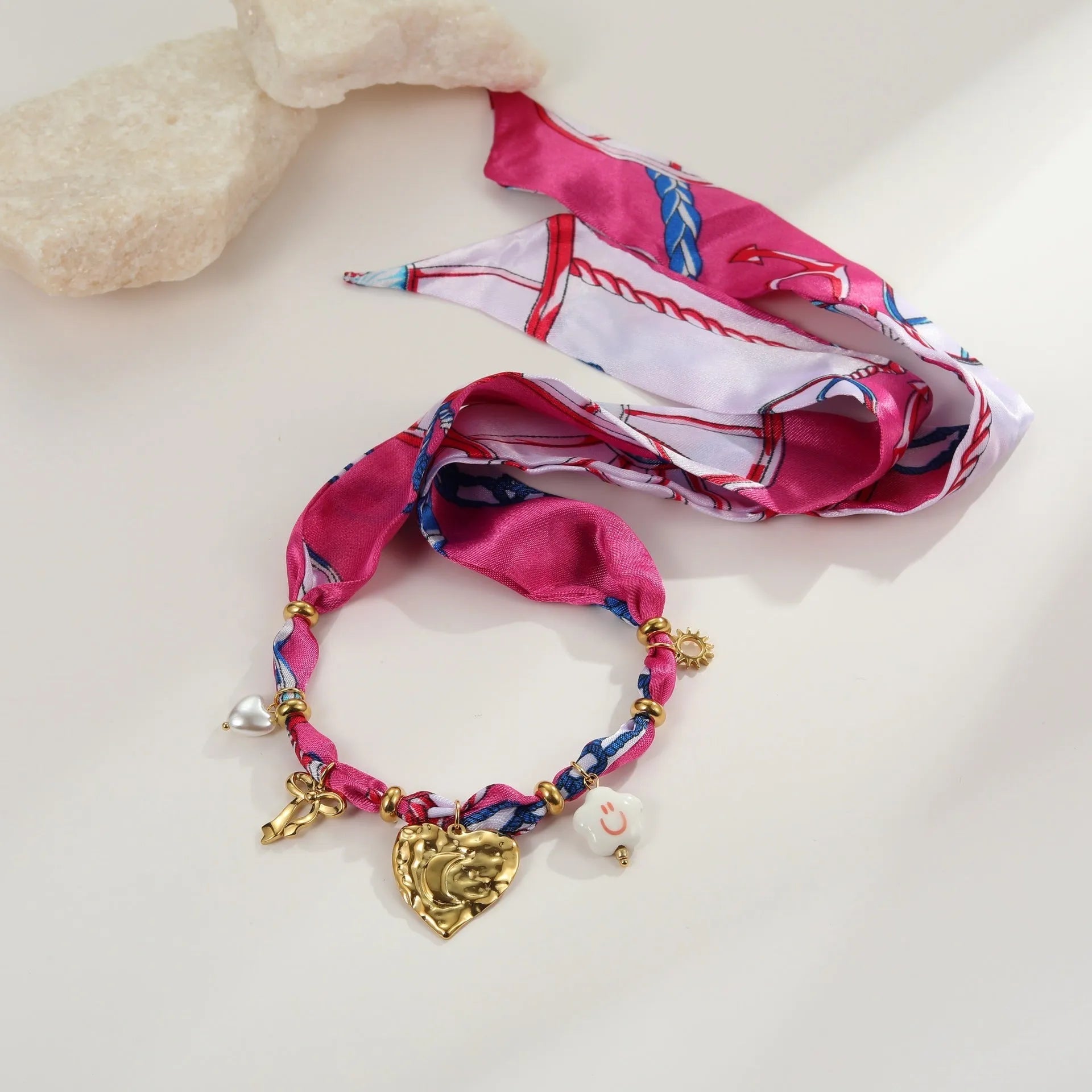 Women's geometric chain necklace and bracelet set with colourful pendant on a white background.