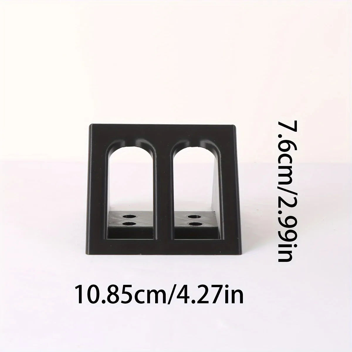 Black punk-style plastic stand for displaying a toy pistol.