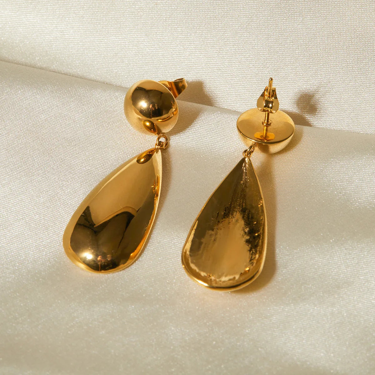 Gold geometric water drop earrings with hemisphere pendant design on stainless steel