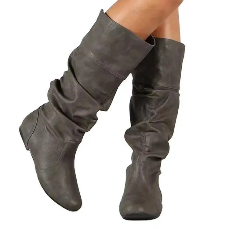 Women's black slip-on flat high cylinder boots with a round toe and rubber sole.