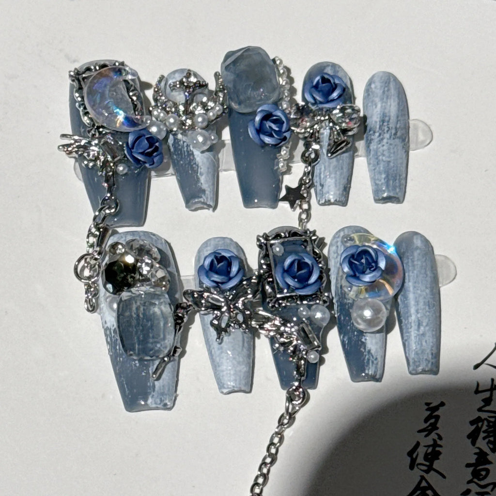 Heavy industry blue manicure nails with rose and tulip floral patterns in plastic armour suit packaging