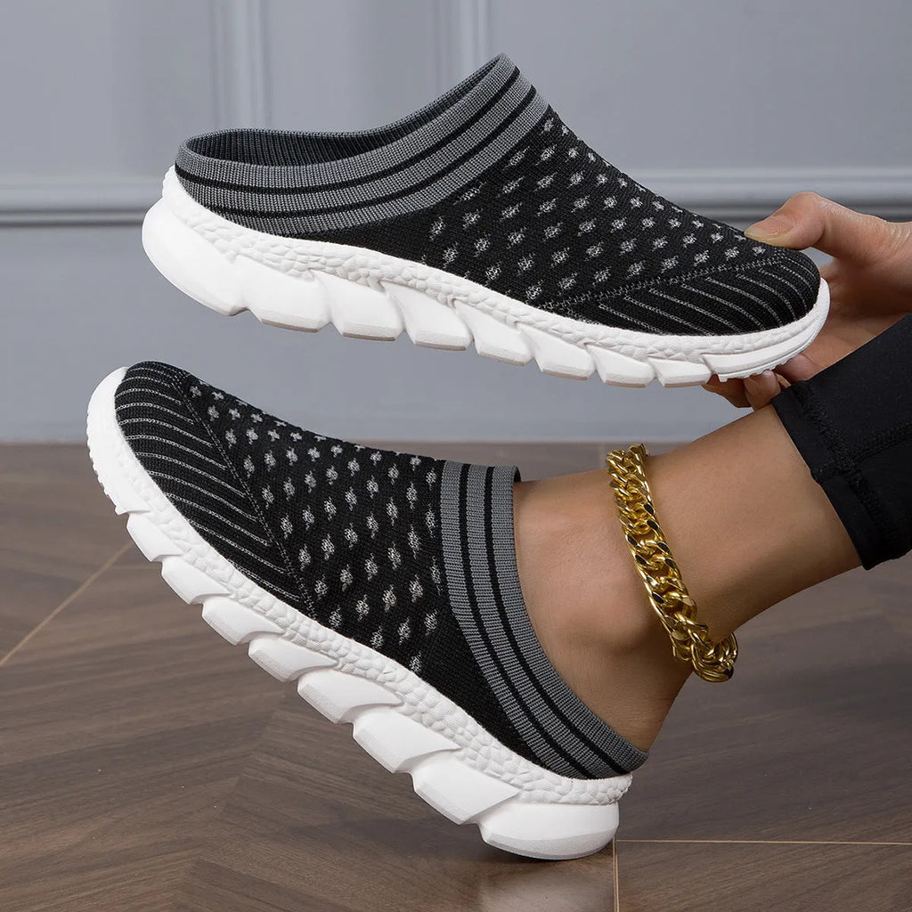 Women's black Flyknit socks semi slipper shoes with striped pattern and hollow-out design on a viscose sole.