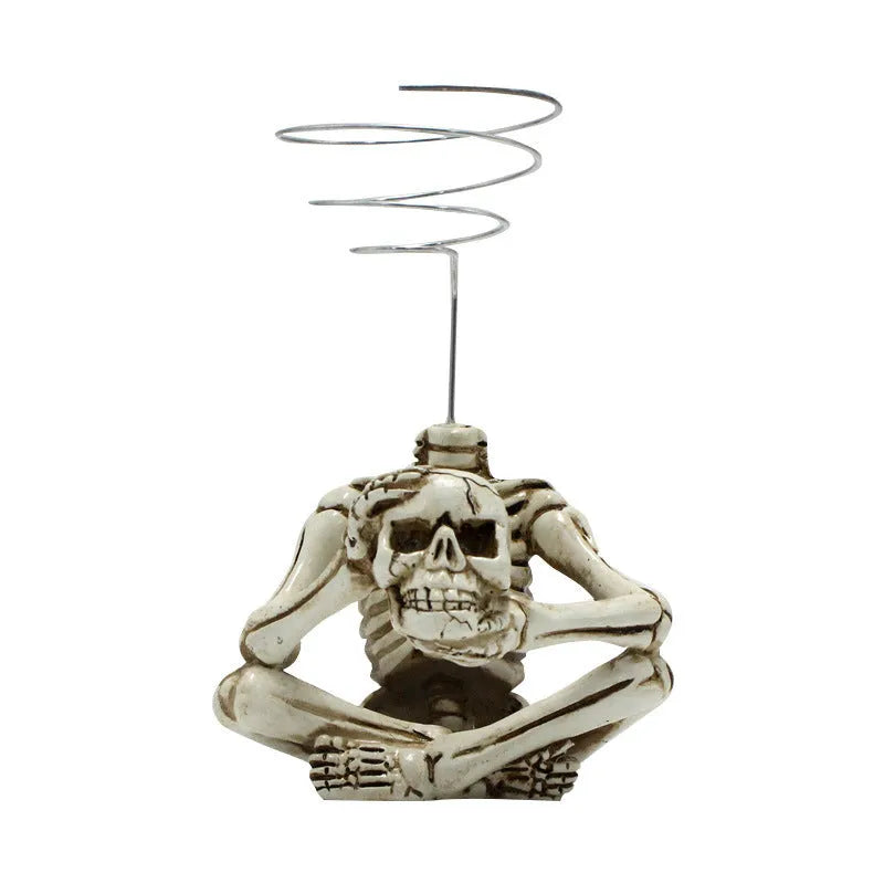Gothic skull resin potted bracket for soilless air plants on a dark surface