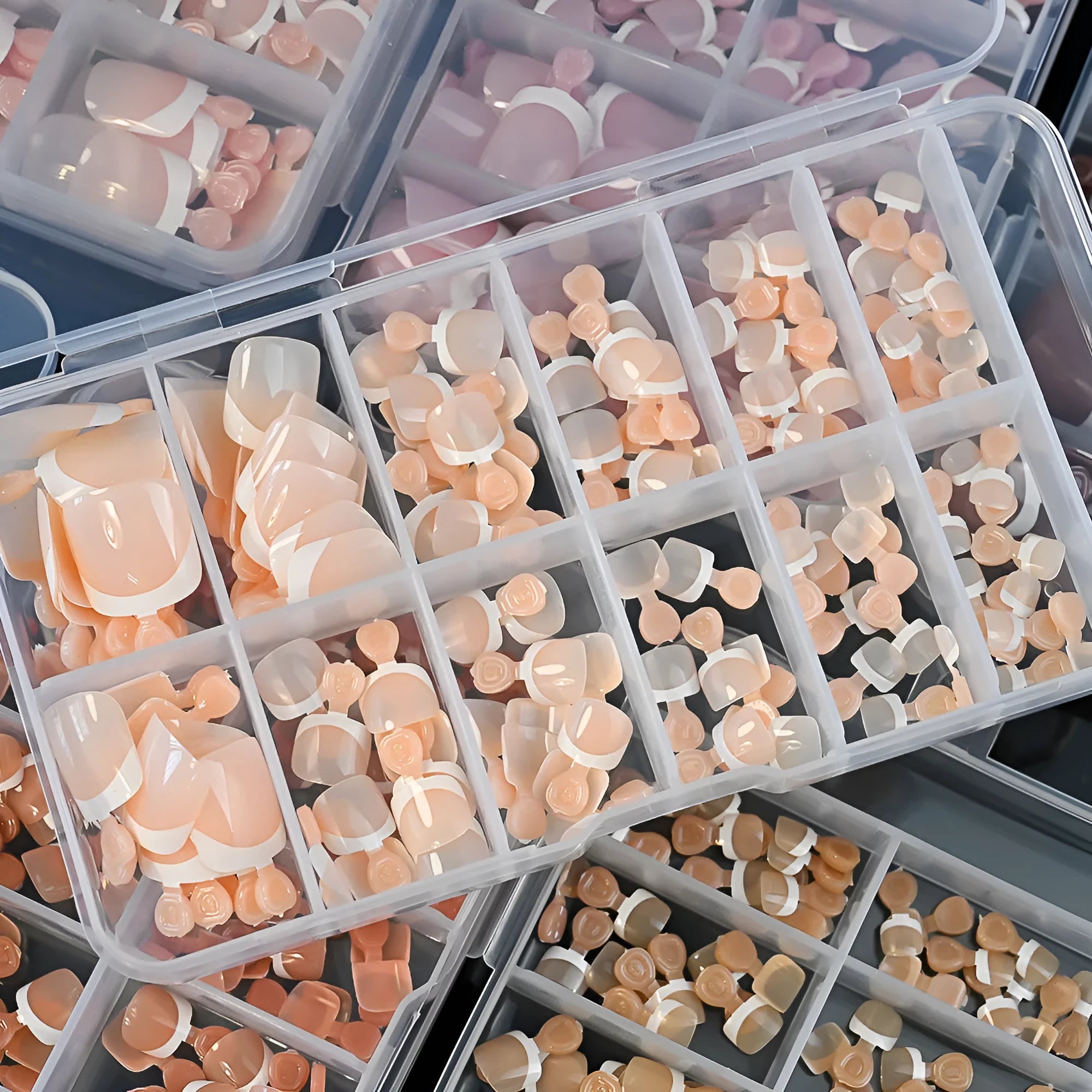 Open box showing 120 French style toe nail pieces with white tips in various nude colours.