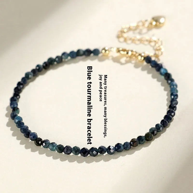 Blue tourmaline bracelet with 3mm cut beads and spacer design on white background