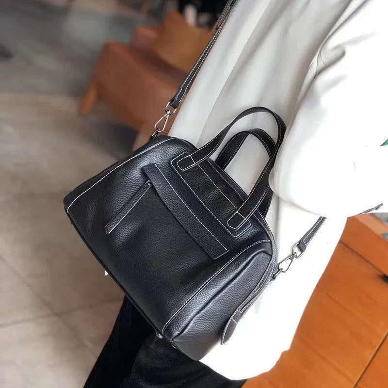 Brown genuine leather messenger bag with a textured lychee pattern, showing front flap and adjustable shoulder strap.
