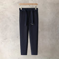 Boy wearing slim straight grey wool trousers with a tapered fit and straight leg opening.