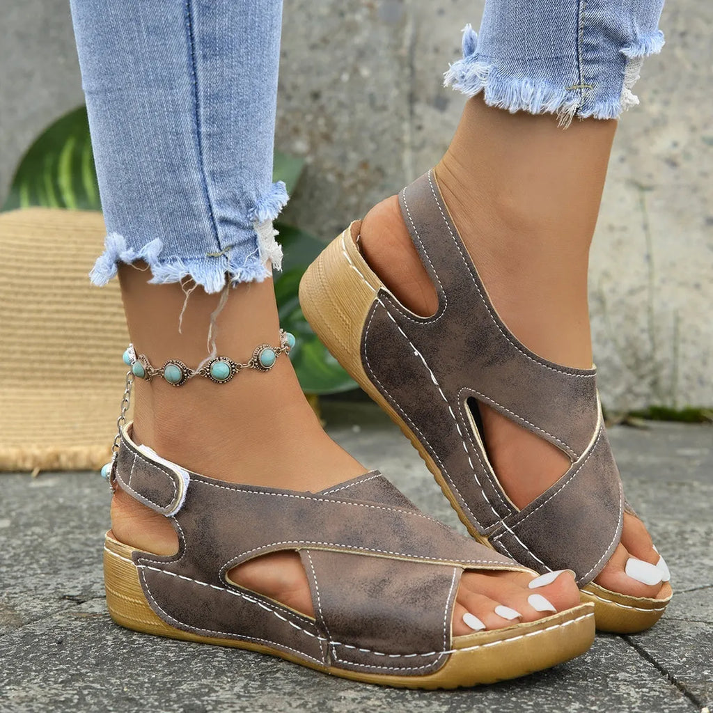 Women's brown Roman platform sandals with skirt detail and Velcro strap on a rubber sole.