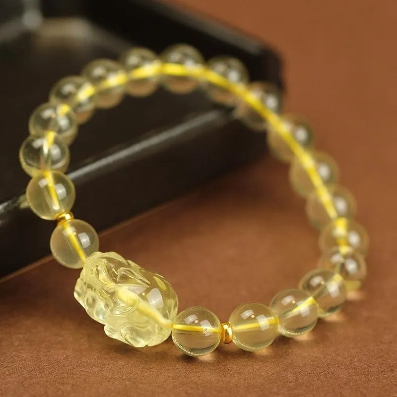 Yellow leather adjustable bracelet with artificial citrine beads and a Pi Xiu charm.