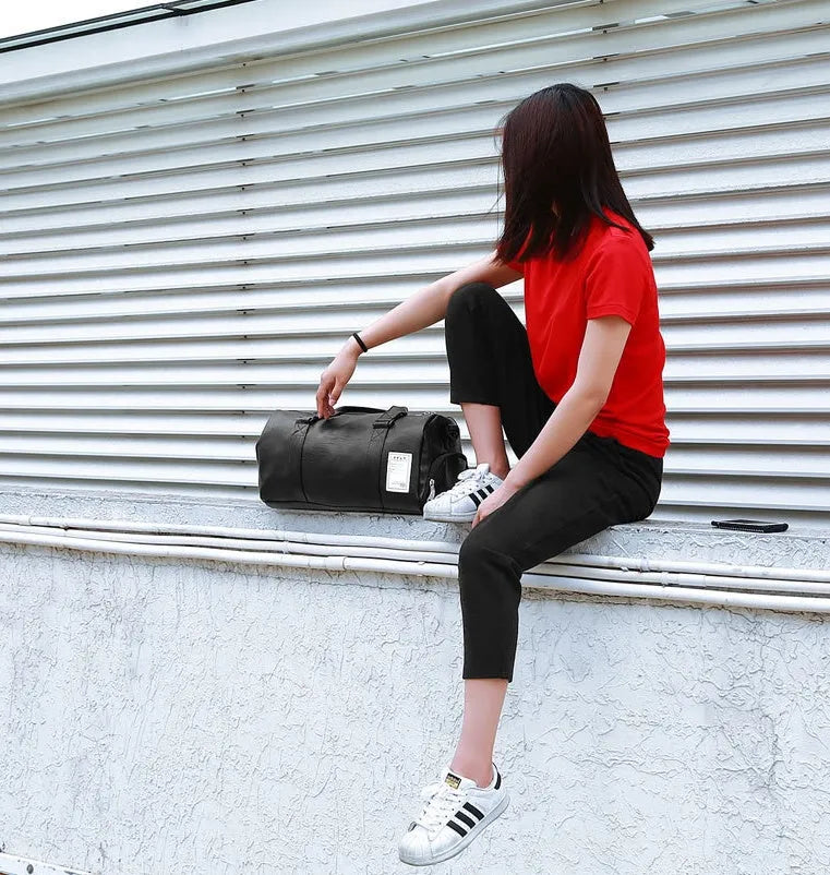 Black waterproof sports duffel bag with separate shoe compartment and diagonal shoulder strap
