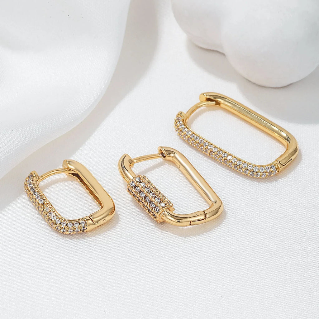 Geometric ear clips set with micro inlaid zircon detailing on copper, showing ellipse and quadrilateral shapes in gold and white finishes