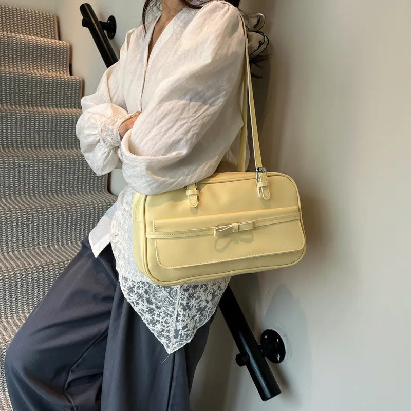 Structured PU leather single-shoulder flap bag in a horizontal square shape with a flap closure.