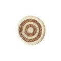 Round natural papyrus straw placemat with tassel edge on a wooden table.