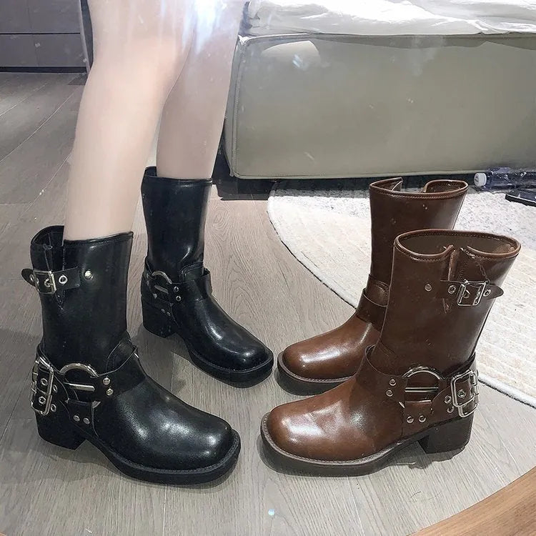 Women's black platform boots with a large silver belt buckle and mid-calf height.