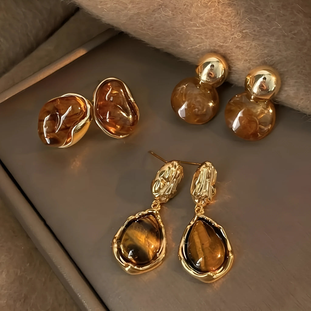 A set of three handmade geometric tassel earrings for women: Amber, round piece, and water drop styles.