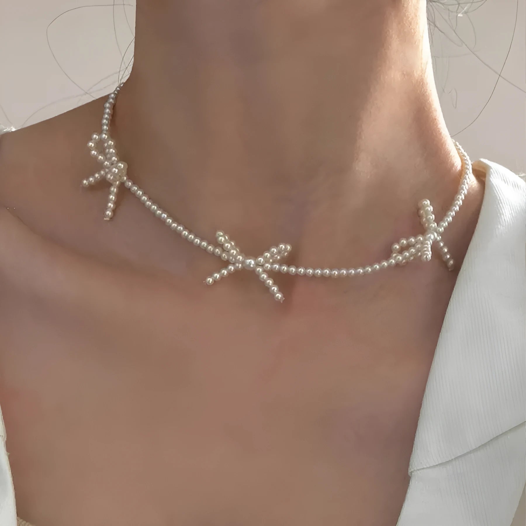 White imitation pearl necklace for women with an adjustable chain and a geometric sweet bow charm.
