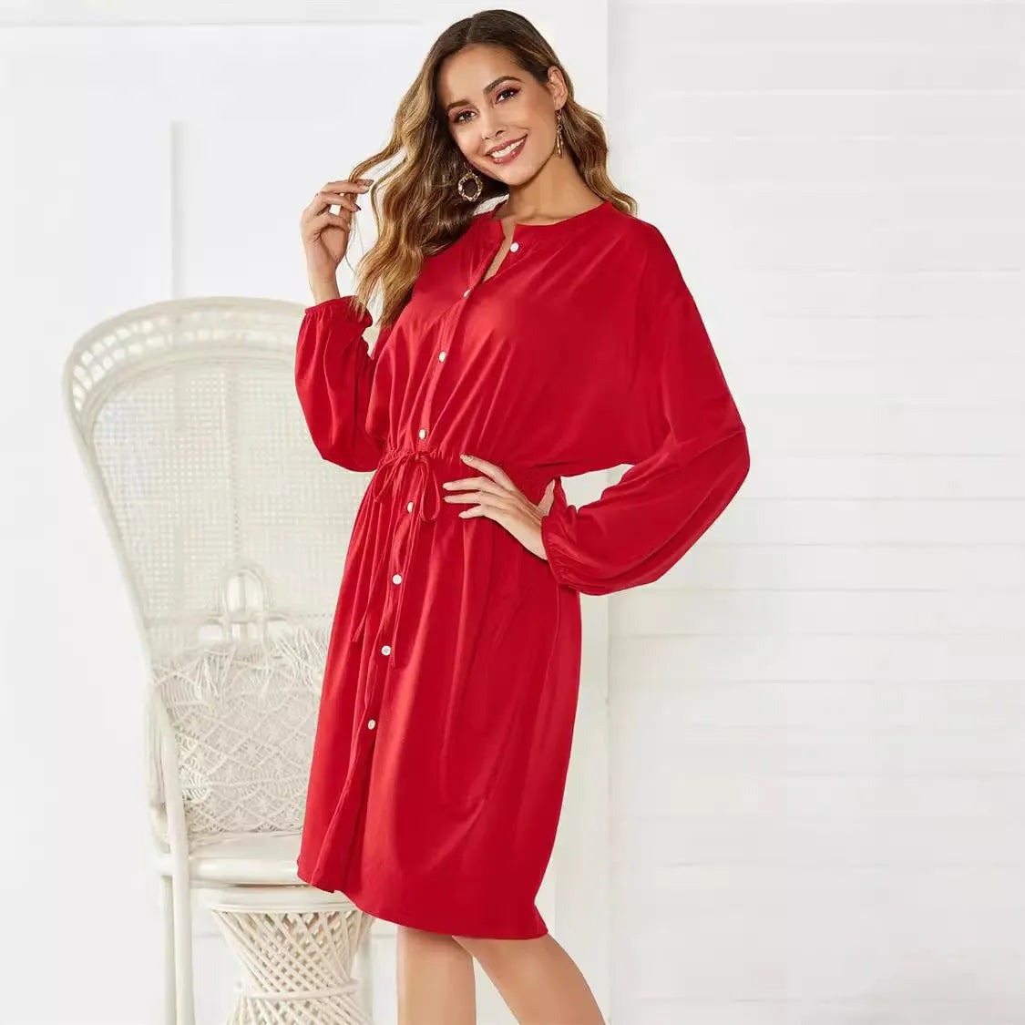 Black or red A-line mid-length dress with elastic waist, long sleeves with elastic cuffs, and a loose cinching belt.