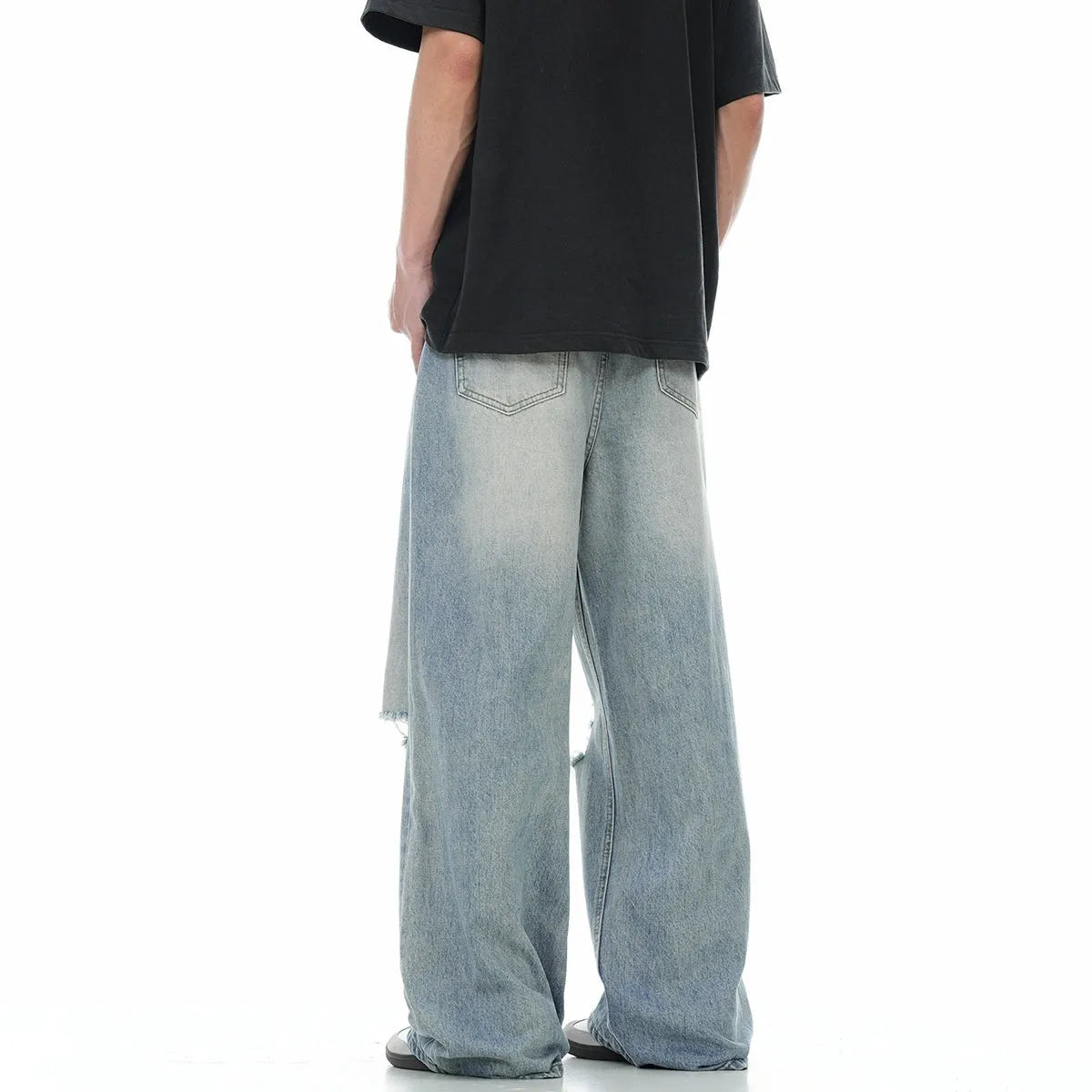 Blue men's straight-leg jeans with ripped distressing detail on the legs.