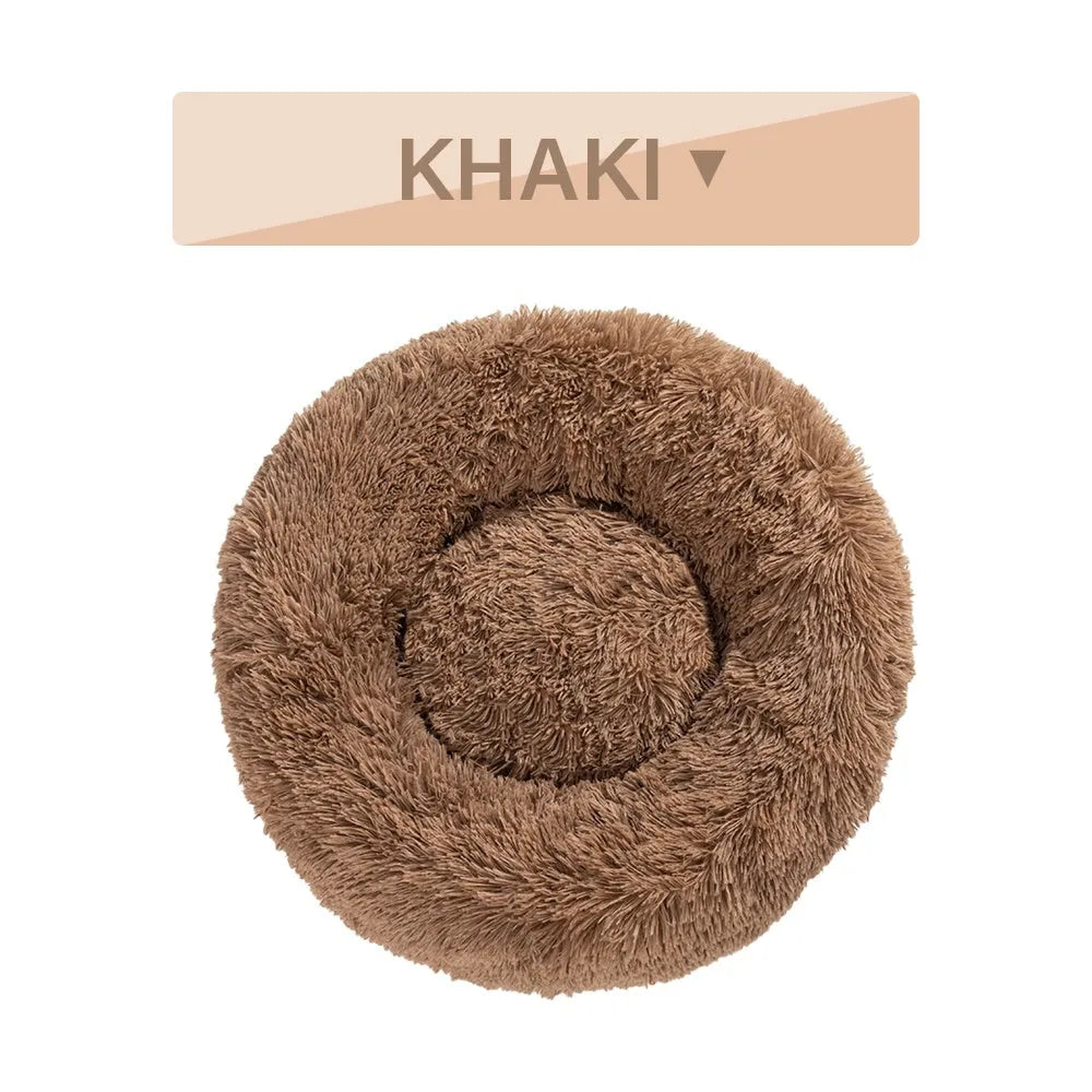 Fluffy grey donut dog bed with raised rim, shown with a small dog sleeping inside.