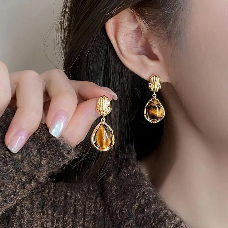 A set of three handmade geometric tassel earrings for women: Amber, round piece, and water drop styles.