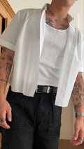 White men's cropped short sleeve polyester shirt on a hanger, plain design.