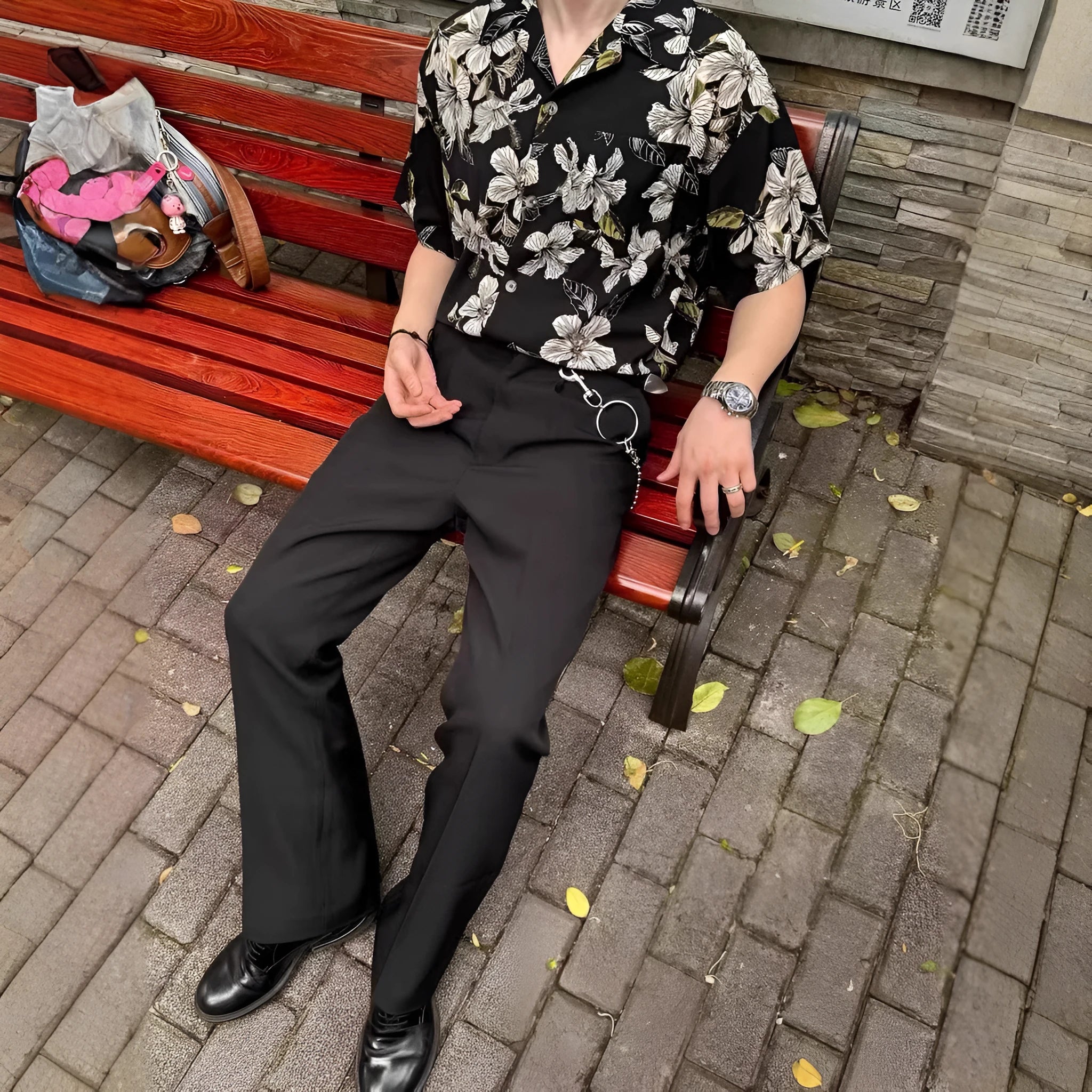 Man wearing a black ice silk shirt with floral print, Cuban collar, and short sleeves.