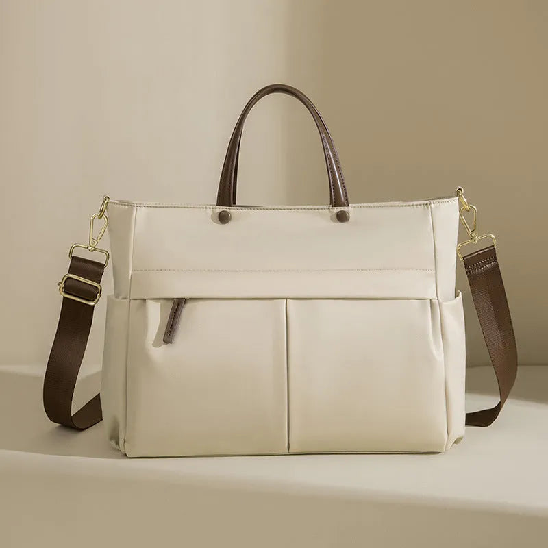 Women's Oxford cloth briefcase with shoulder strap showing open pocket organisation and contrast stitching details