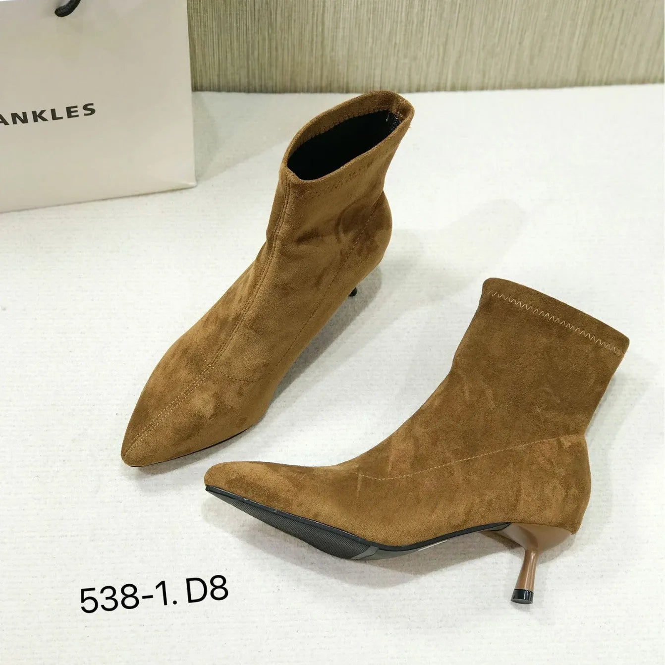 Black pointed toe women's ankle boots with a stiletto heel on a white background.