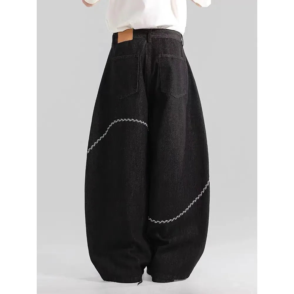 Black straight-leg denim trousers with mid-waist zip fly design on hanger