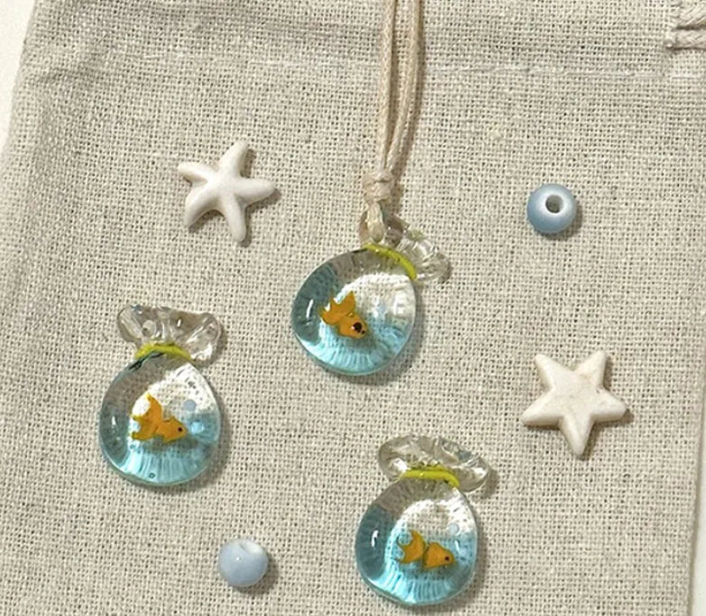 Women's necklace with coloured glaze joker pendant on a woven cotton and linen clavicle chain.